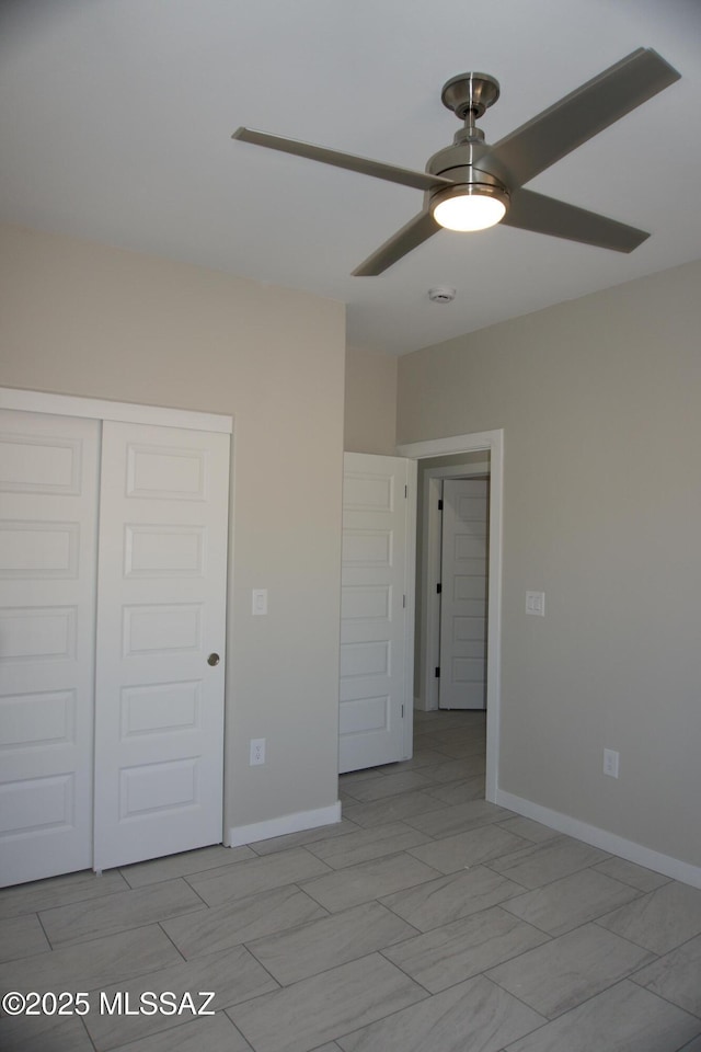 unfurnished bedroom with a closet, baseboards, and ceiling fan