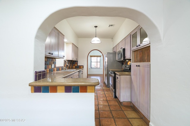 3737 E Pima St, Tucson, AZ 85716 - kitchen with a peninsula, visible vents, appliances with stainless steel finishes, a sink, and decorative backsplash