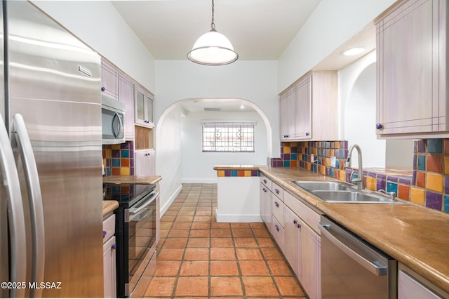 3737 E Pima St, Tucson, AZ 85716 - kitchen with tasteful backsplash, baseboards, arched walkways, a sink, and stainless steel appliances