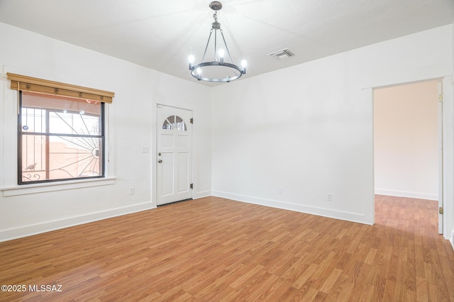3737 E Pima St, Tucson, AZ 85716 - unfurnished room with visible vents, baseboards, light wood finished floors, and an inviting chandelier