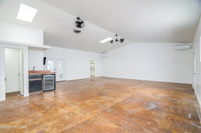 3737 E Pima St, Tucson, AZ 85716 - interior space with concrete floors, baseboards, a wall mounted air conditioner, vaulted ceiling with skylight, and wine cooler