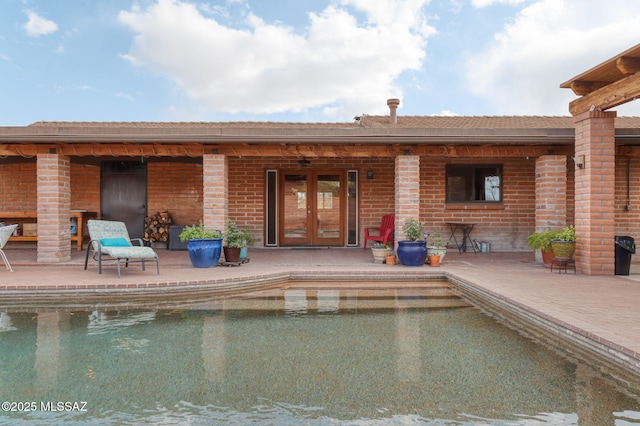 6341 E Brian Kent St, Tucson, AZ 85710 - rear view of property featuring an outdoor pool, a patio area, a ceiling fan, brick siding, and french doors