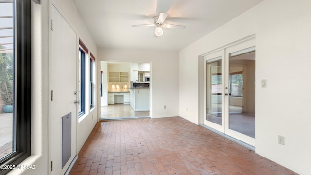 kitchen featuring appliances with stainless steel finishes, a peninsula, a kitchen island, ceiling fan, and a sink