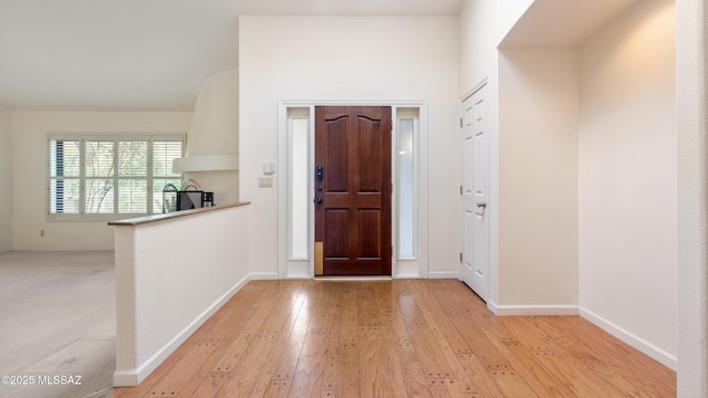 foyer with light wood-style flooring and baseboards