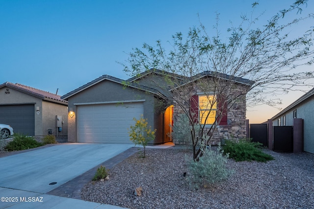 ranch-style house with stucco siding, driveway, stone siding, and a garage