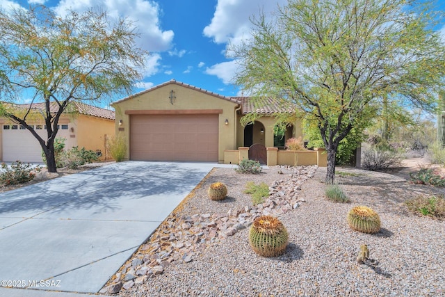 mediterranean / spanish-style house featuring a tile roof, an attached garage, stucco siding, and driveway