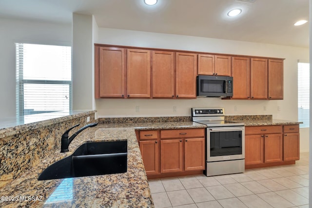12171 N Golden Mirror Dr, Marana, AZ 85658 - kitchen featuring stainless steel range with electric stovetop, a sink, stone countertops, brown cabinets, and recessed lighting