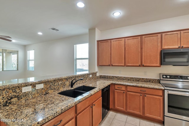 12171 N Golden Mirror Dr, Marana, AZ 85658 - kitchen with black appliances, a sink, brown cabinetry, dark stone counters, and recessed lighting