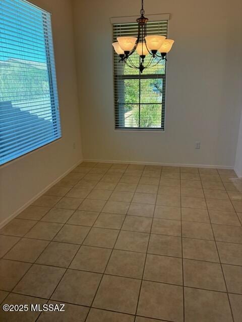 12171 N Golden Mirror Dr, Marana, AZ 85658 - unfurnished room featuring a chandelier, light tile patterned floors, and baseboards