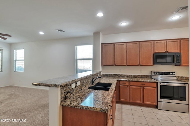 kitchen with brown cabinetry, a sink, electric stove, and ceiling fan