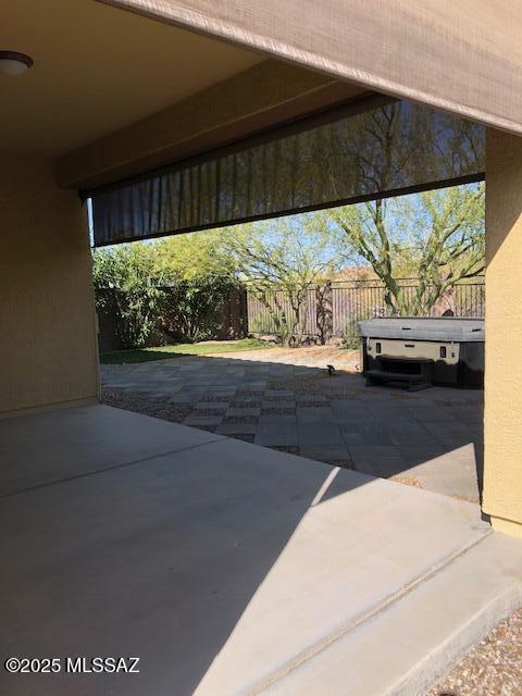 view of patio / terrace with a hot tub and a fenced backyard