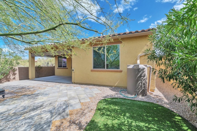exterior space featuring fence, a patio, and stucco siding