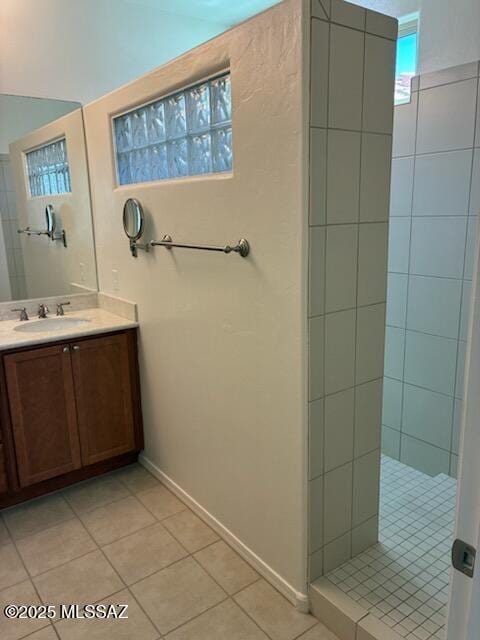 12171 N Golden Mirror Dr, Marana, AZ 85658 - bathroom with tile patterned floors, a walk in shower, vanity, and baseboards
