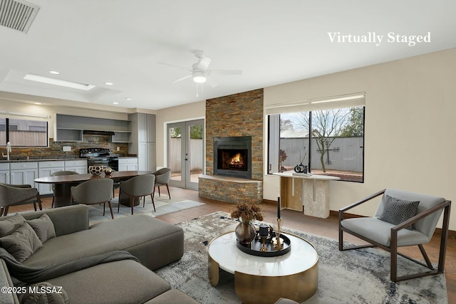 living area featuring recessed lighting, french doors, light wood-style flooring, a ceiling fan, and visible vents