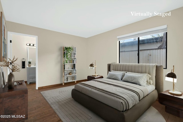 bedroom featuring baseboards, connected bathroom, and wood finished floors