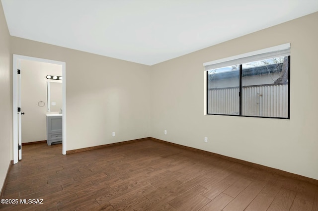 empty room featuring wood finished floors and baseboards