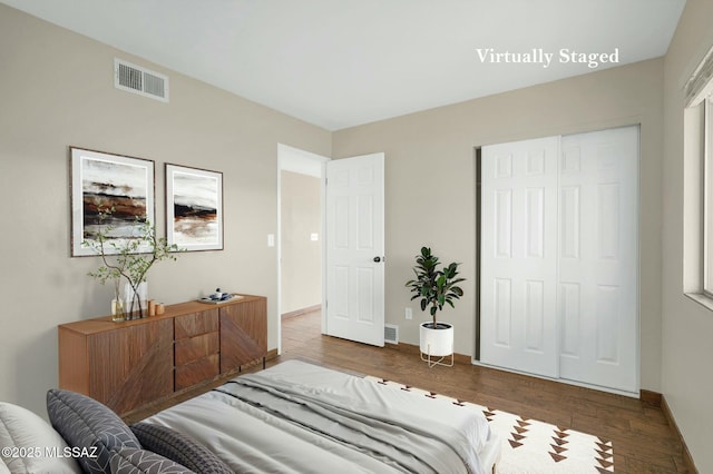 bedroom featuring wood finished floors, baseboards, and visible vents