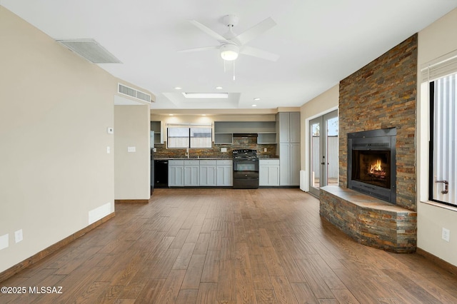 kitchen featuring tasteful backsplash, visible vents, black appliances, and dark countertops