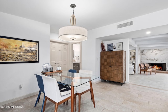 dining space featuring visible vents, baseboards, and a fireplace