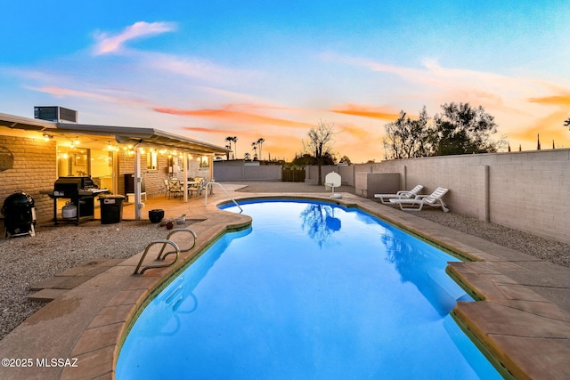 view of swimming pool featuring central air condition unit, a fenced backyard, a fenced in pool, and a patio area