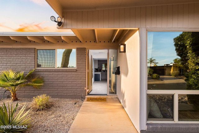 entrance to property featuring brick siding