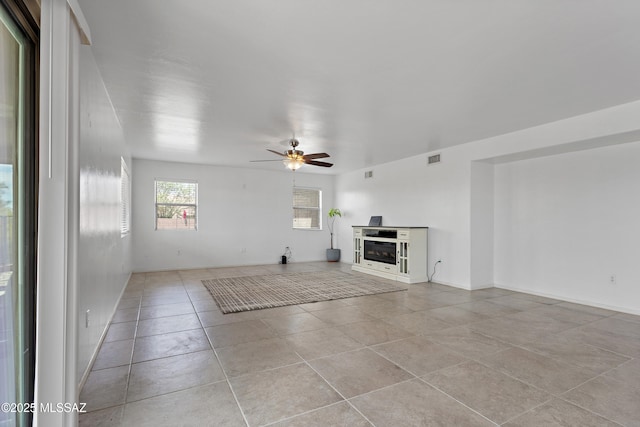 761 W Grantham St, Vail, AZ 85641 - unfurnished living room with light tile patterned floors, visible vents, a glass covered fireplace, and ceiling fan