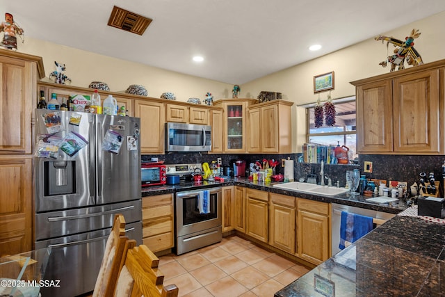 kitchen featuring decorative backsplash, tile countertops, a sink, and appliances with stainless steel finishes