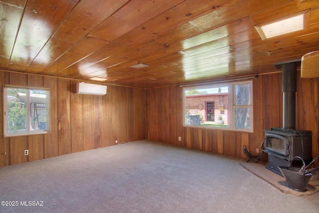 unfurnished living room featuring wood walls, a wood stove, wooden ceiling, and a healthy amount of sunlight