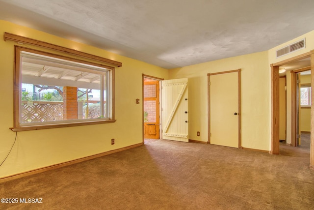 unfurnished bedroom with carpet flooring, visible vents, and baseboards