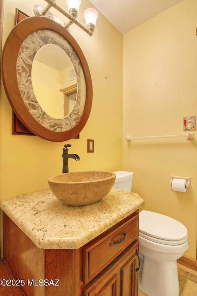 bathroom featuring toilet and vanity