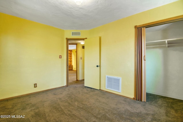 unfurnished bedroom with carpet, visible vents, a closet, and baseboards