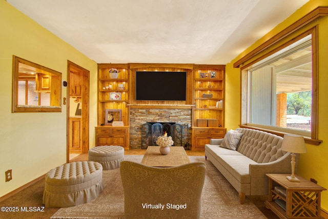 living room with a fireplace and baseboards