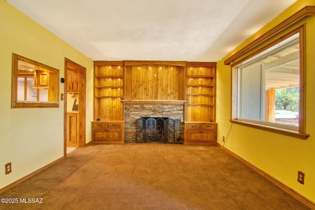 unfurnished living room with a fireplace, baseboards, and carpet floors