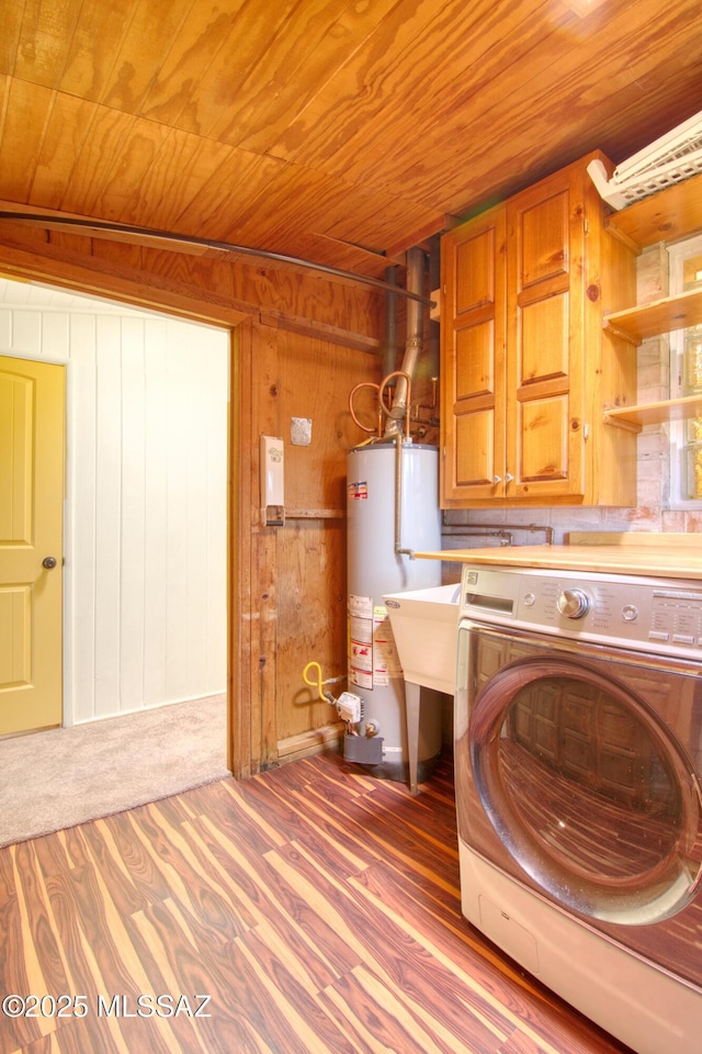 clothes washing area with gas water heater, wood ceiling, wood finished floors, wood walls, and washer / dryer