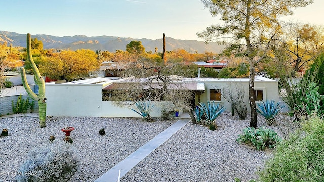 exterior space with a mountain view and stucco siding