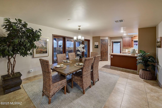 dining area featuring an inviting chandelier, visible vents, and light tile patterned floors