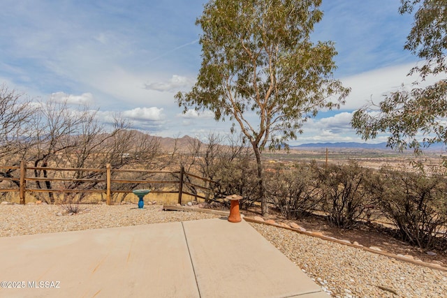 view of yard featuring a patio area, a mountain view, and fence