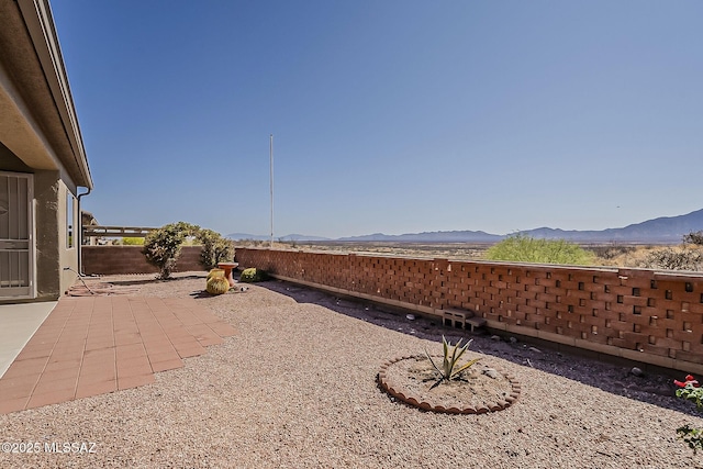 view of patio with a mountain view and a fenced backyard