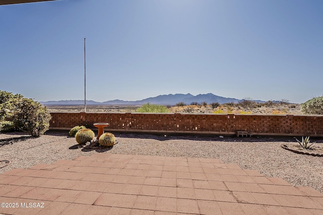 view of patio / terrace with a mountain view and fence