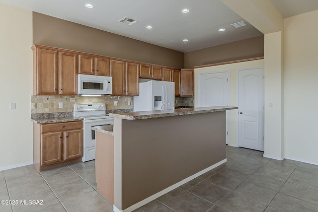 kitchen featuring tile patterned floors, tasteful backsplash, white appliances, and visible vents