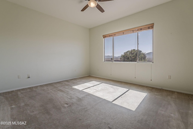 empty room with ceiling fan, baseboards, and carpet