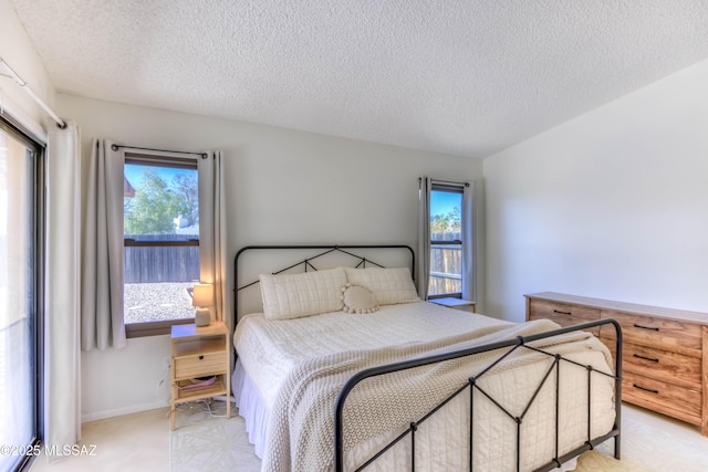 bedroom with a textured ceiling and multiple windows