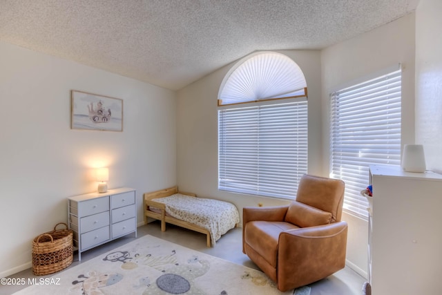 bedroom with vaulted ceiling, multiple windows, and a textured ceiling