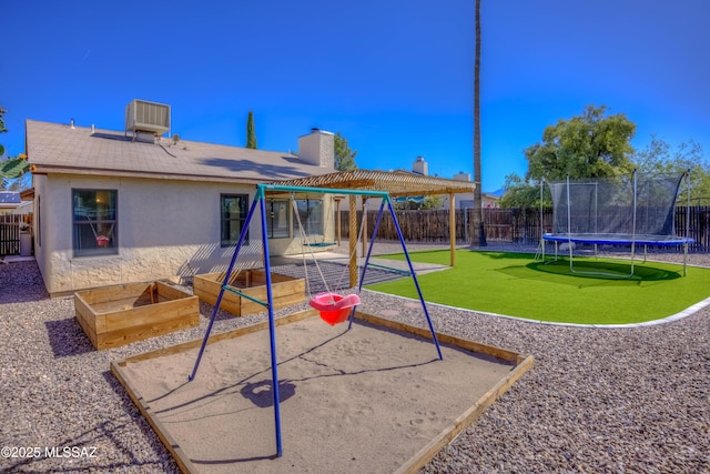 view of play area with a fenced backyard, central AC unit, a gazebo, and a trampoline
