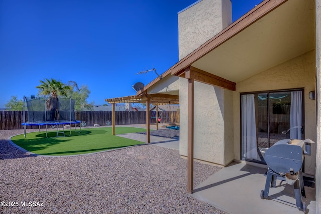 view of patio / terrace featuring a fenced backyard, a trampoline, and area for grilling