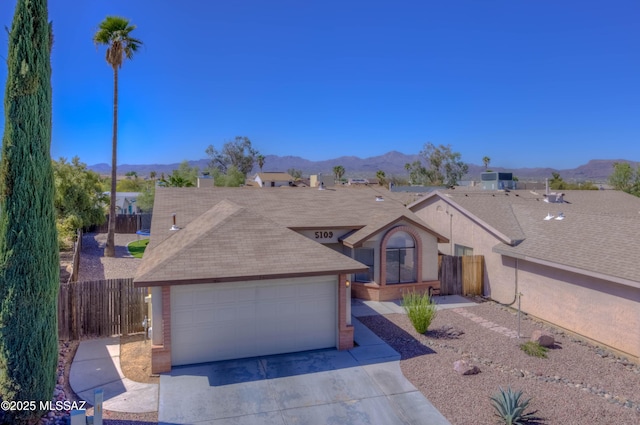 ranch-style home with brick siding, fence, and a mountain view