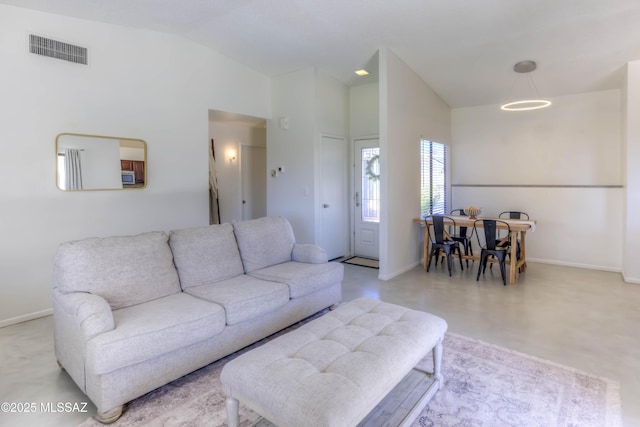 living area with high vaulted ceiling, baseboards, and visible vents