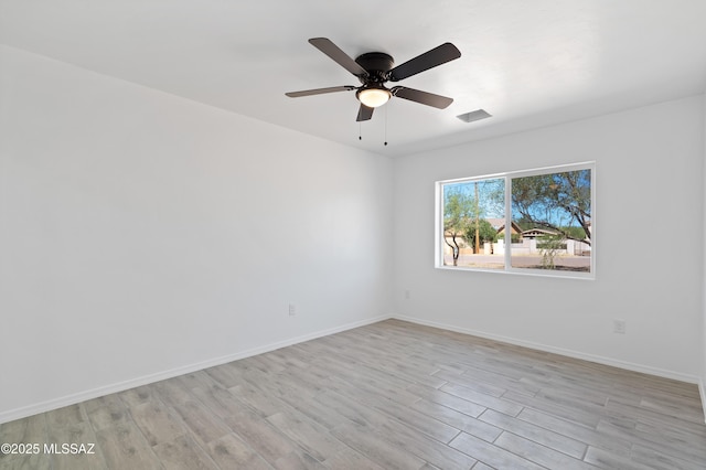 spare room featuring visible vents, baseboards, light wood-type flooring, and ceiling fan