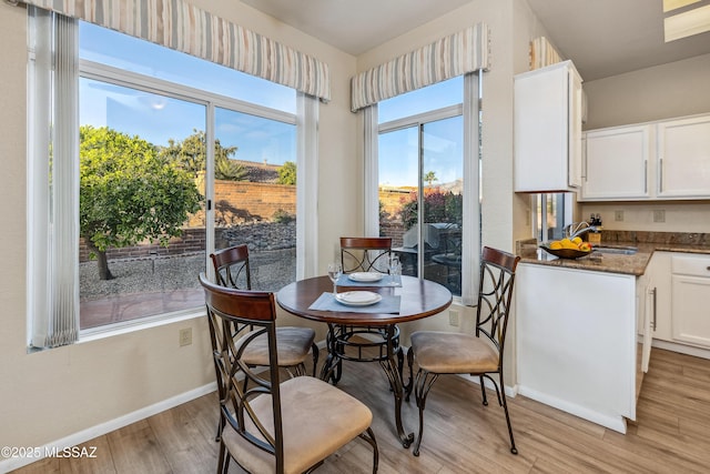 dining room featuring light wood-style flooring and baseboards