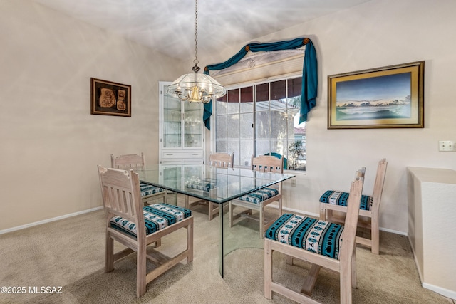 carpeted dining area with a notable chandelier and baseboards